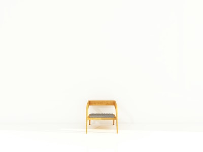 棕色木框灰色软垫扶手椅靠近白色油漆墙